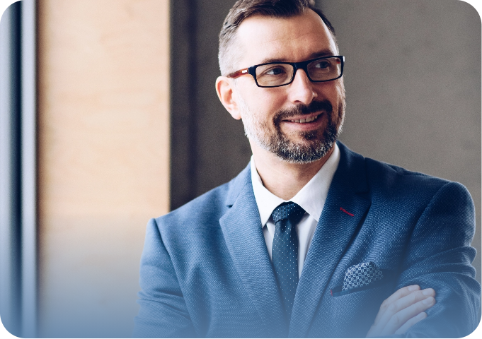 Homem de negócios sorridente usando terno azul e óculos, transmitindo confiança e profissionalismo.
